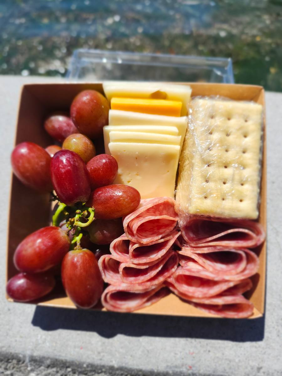 Charcuterie box with grapes, cheese, salami and crackers